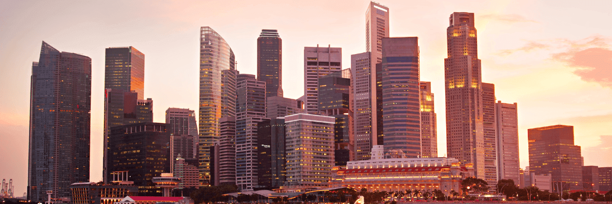 Skyline of modern skyscrapers against a sunset sky with warm hues